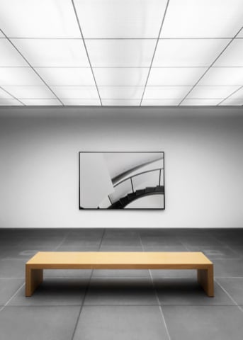 A bench in a gallery room allowing contemplation of a painting